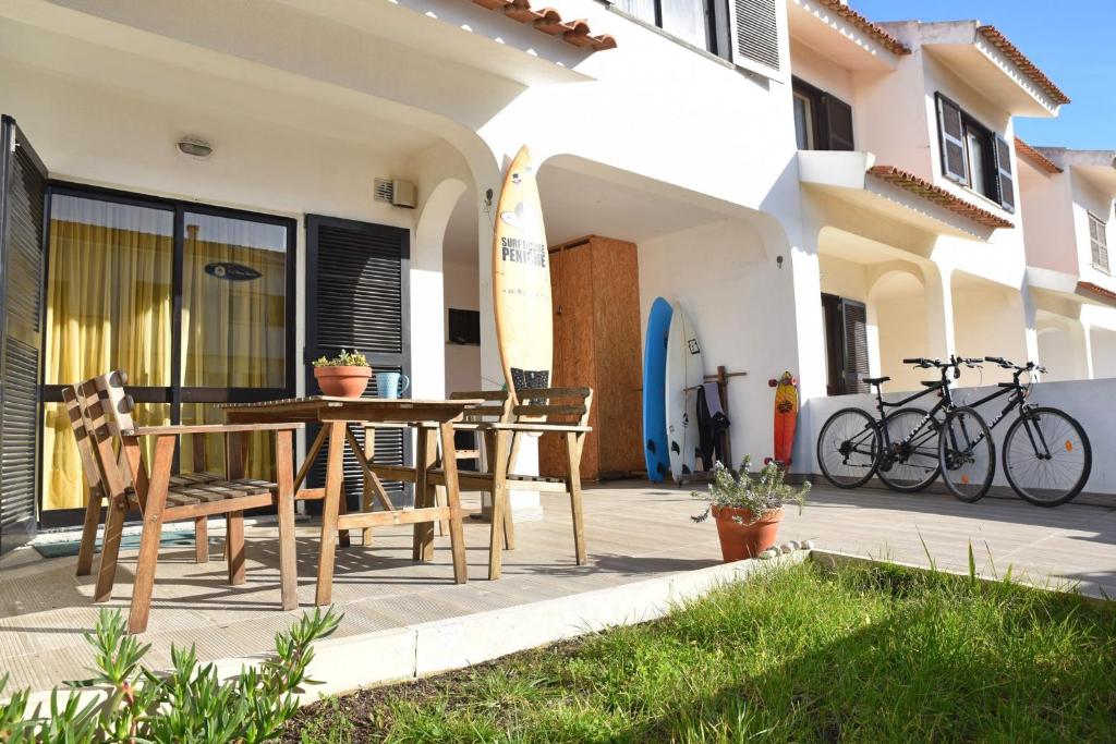 un patio con mesa y sillas frente a una casa en Surf House Peniche, en Baleal