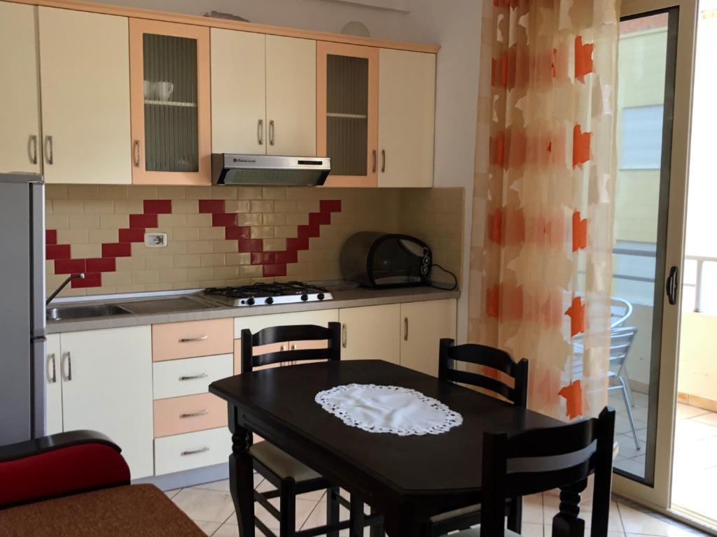 a kitchen with a table and chairs in a room at Sunset apartments in Orikum