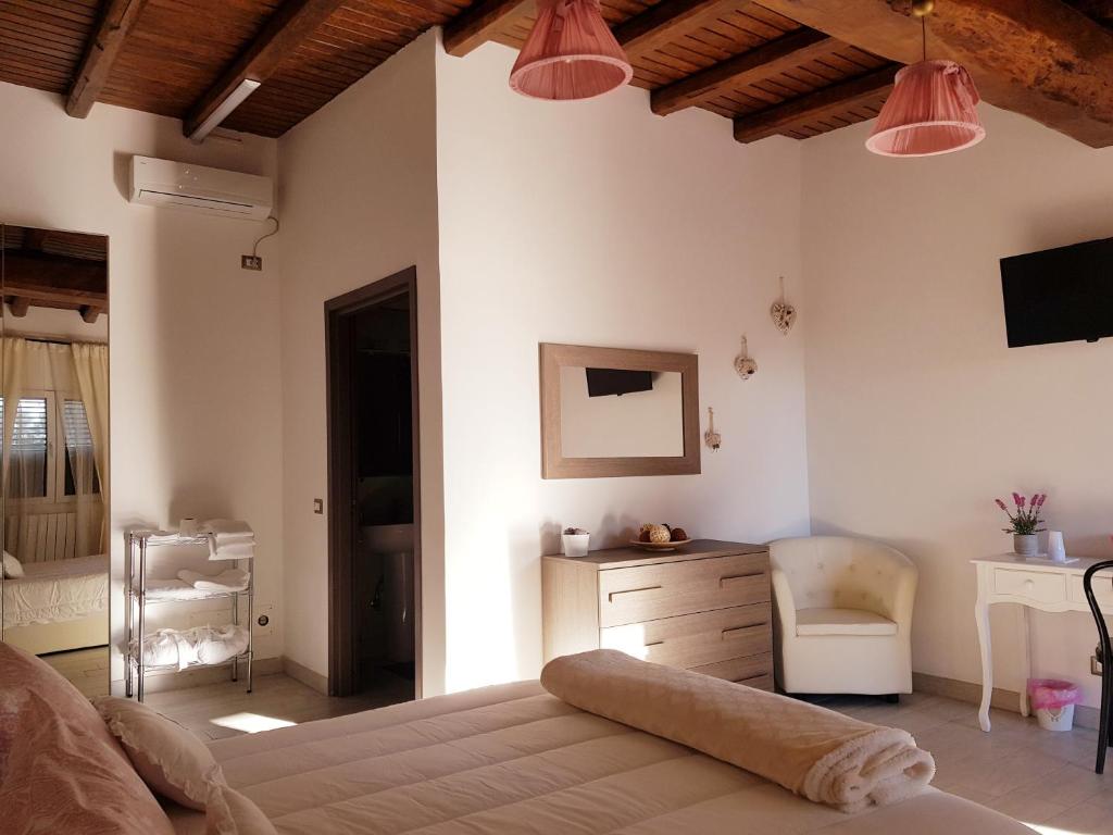 um quarto com uma cama, uma secretária e uma cadeira em L'oasi di Ambra em Ardea