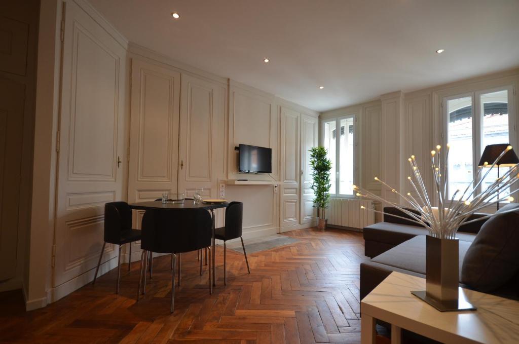 - un salon avec une table et des chaises dans l'établissement Appartements Hôtel de Ville, à Lyon