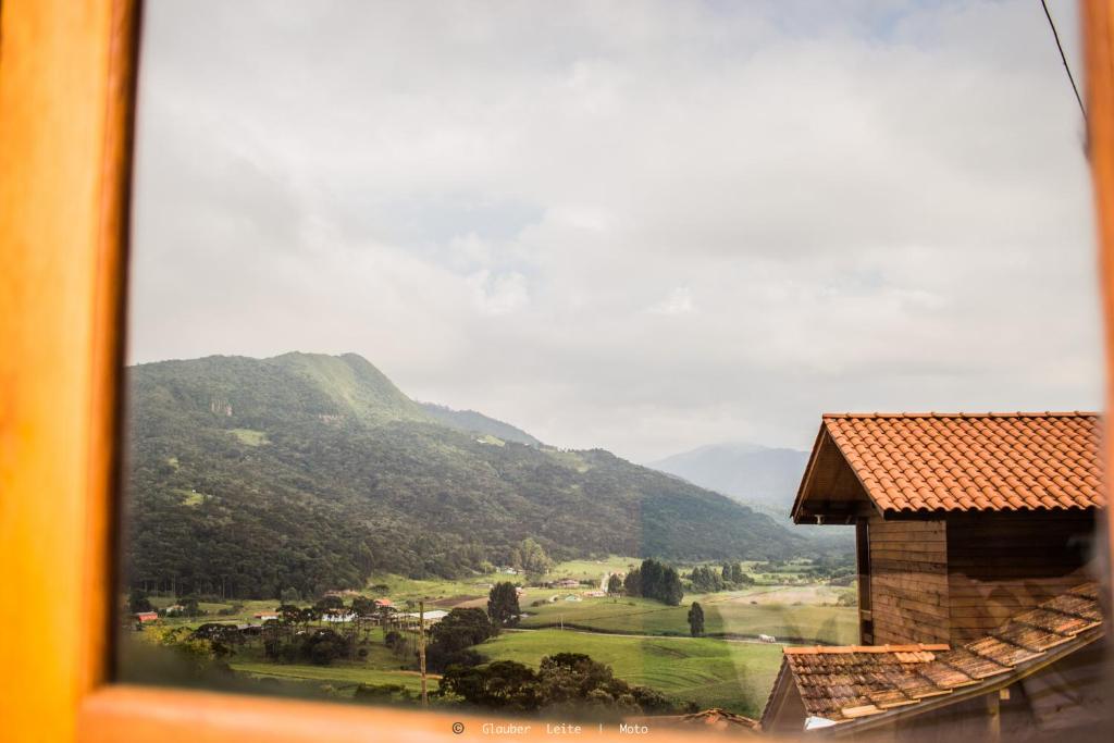 een uitzicht vanuit een raam van een vallei met bergen bij Pousada Sítio Do Trevo in Urubici