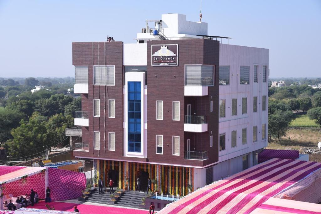 斋浦尔Hotel Le Grande的一座挂着招牌的高砖建筑