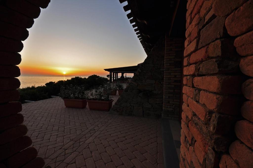 a sunset seen from a brick building with a brick wall at Hotel Corsaro Nero in Portu Maga