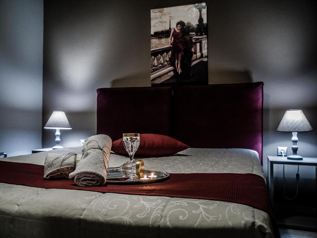 Una cama con una bandeja con una copa de vino. en Gina's Studios, en Aliveri