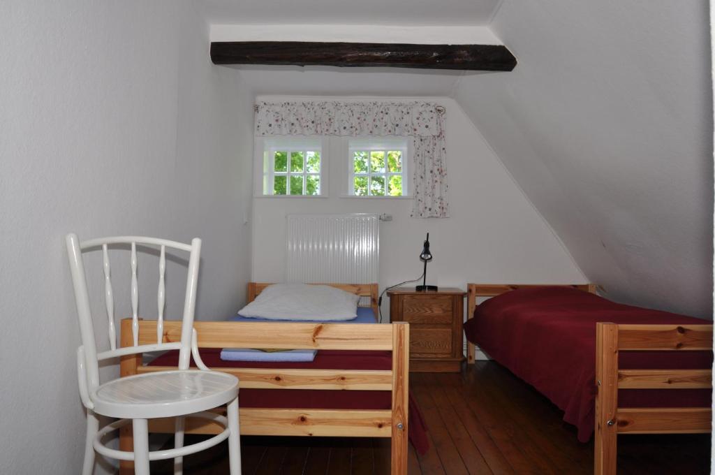 een slaapkamer met een bed, een stoel en een raam bij Ferienhäuser Armsen in Kirchlinteln