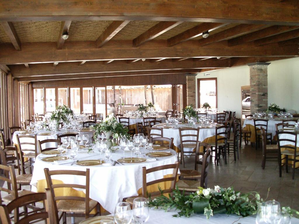a banquet hall with tables and chairs with white tablecloths at Hotel Corsaro Nero in Portu Maga