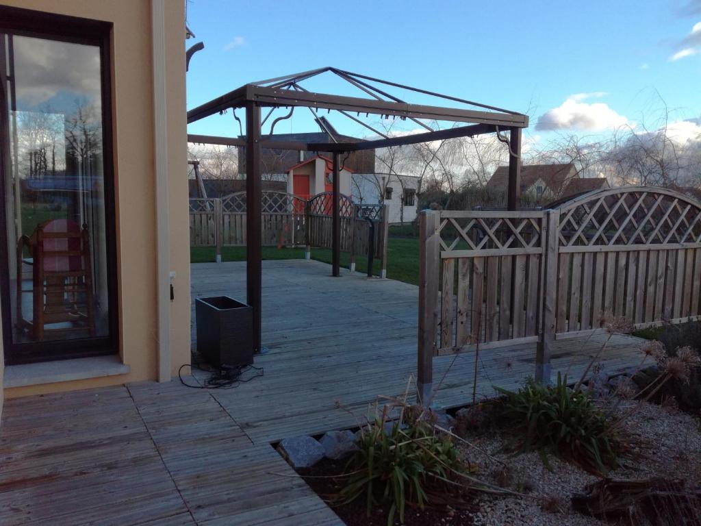 une terrasse en bois avec une porte en bois et un pavillon dans l'établissement Chambre proche du circuit 2415 route des vignes, à Fillé