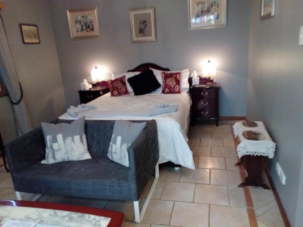 - une chambre avec un lit, un canapé et une chaise dans l'établissement York's Lookout Lodge Bed And Breakfast, à York