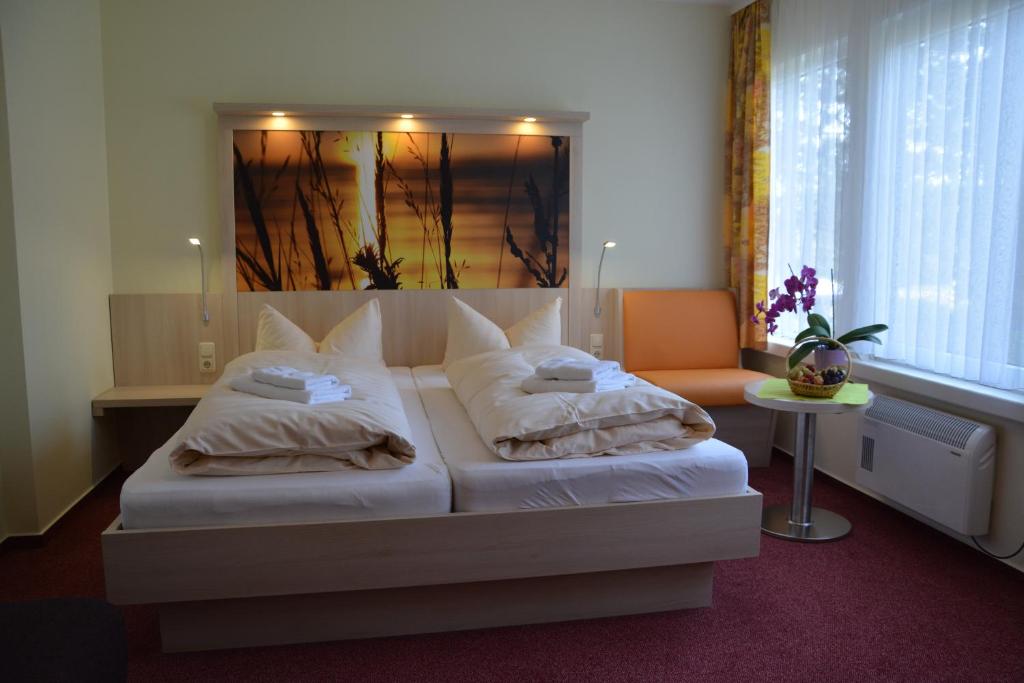 a bedroom with a bed with two pillows at Hotel im Ferienpark Retgendorf in Retgendorf