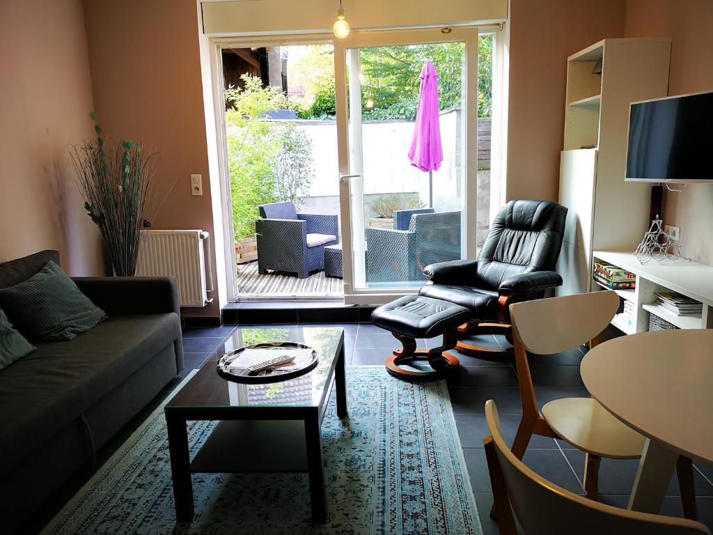 ein Wohnzimmer mit einem Sofa und einem Tisch in der Unterkunft L'ARBOGAST in Herrlisheim