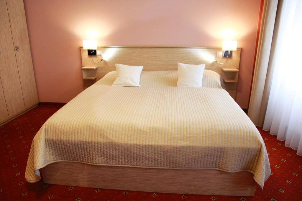 a bedroom with a large white bed with two pillows at Pension Dvořák in Karlovy Vary
