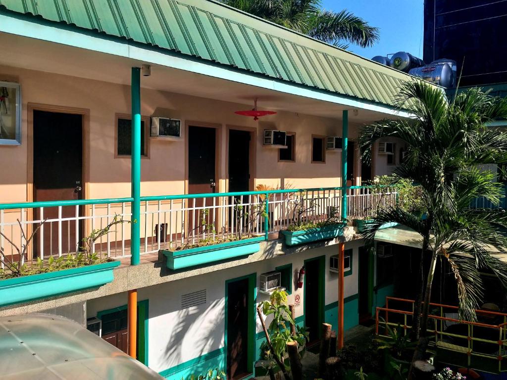 un edificio con balconi e un edificio con una palma di Park Vil-la Apartelle a Manila