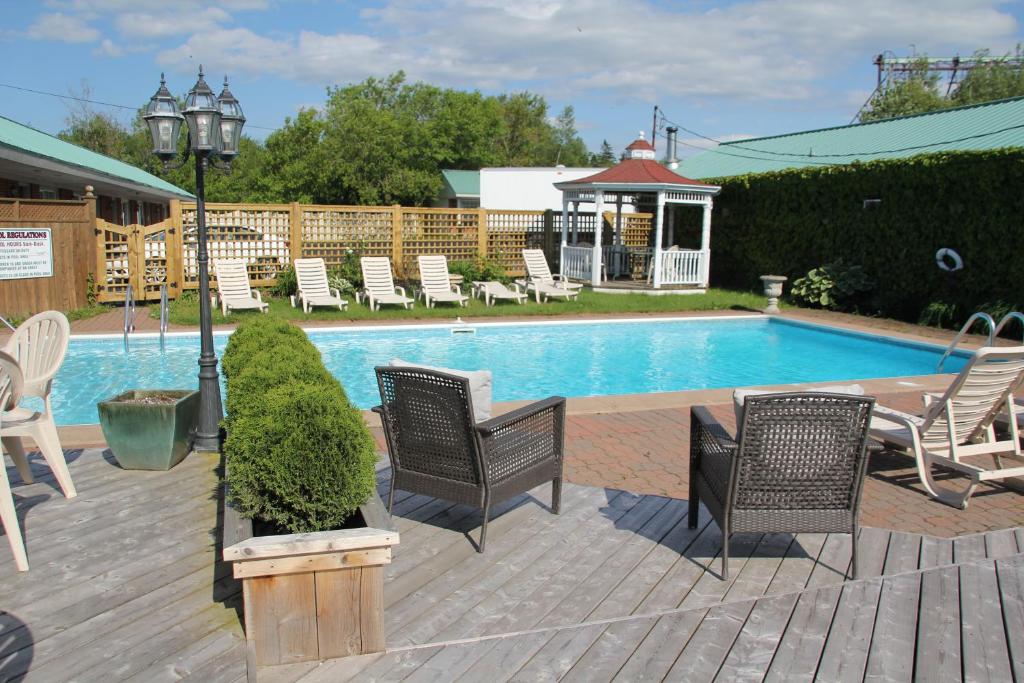 una piscina con sillas, una mesa y un poste de luz en Willow Bend Motel, en Truro