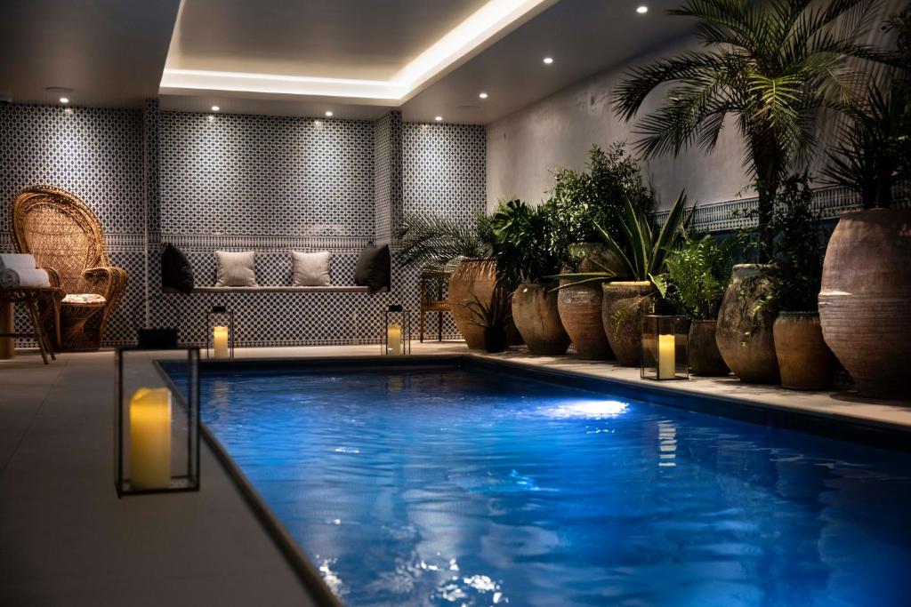 a swimming pool in a room with potted plants at Hôtel Montecristo in Paris