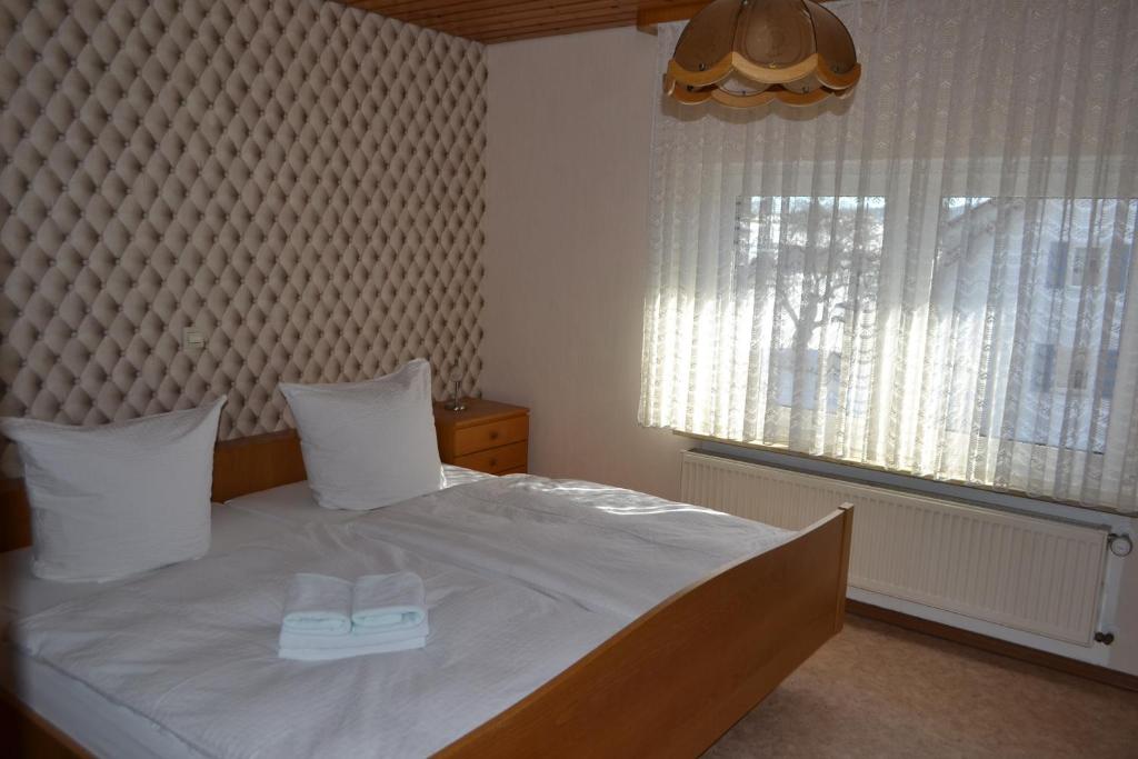 a bedroom with a bed with two white towels on it at Landgasthaus Krone in St. Johann in Sankt Johann