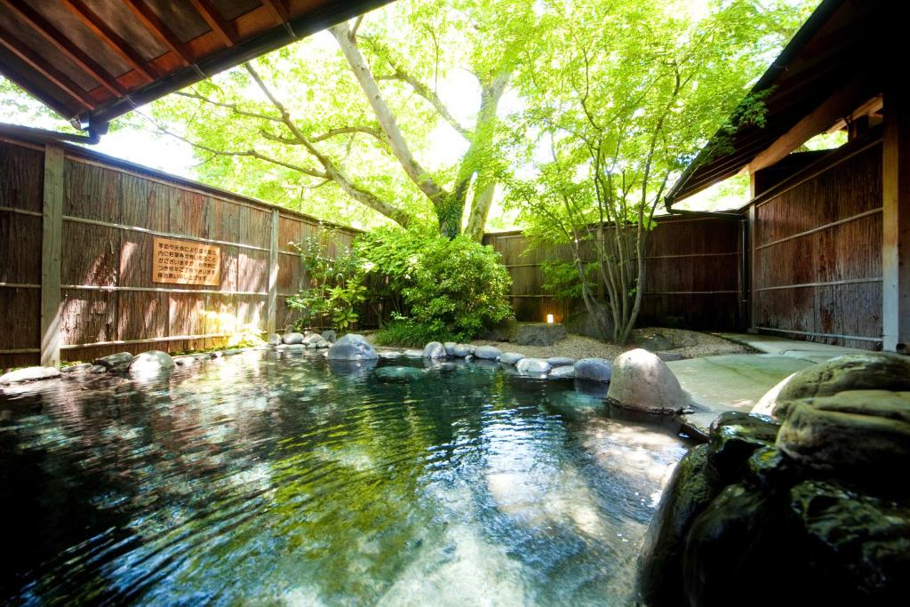 basen wodny z drzewem w tle w obiekcie Ryotei Tanokura w mieście Yufu