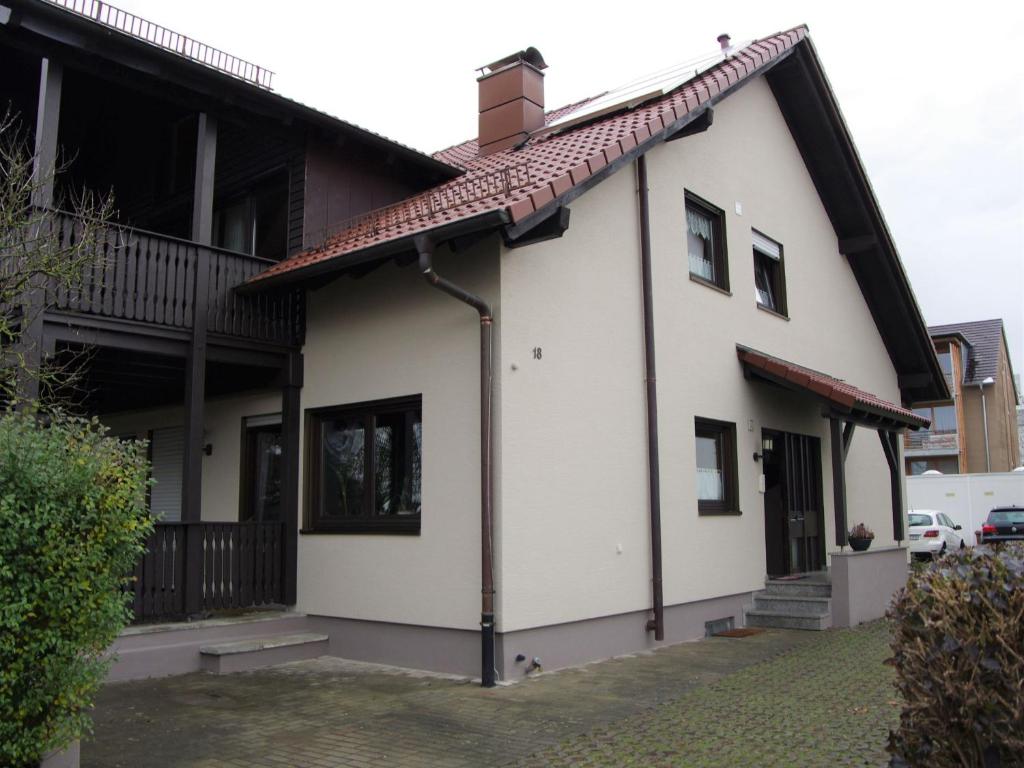 Casa blanca con techo rojo en Ferienwohnung Tea en Eriskirch