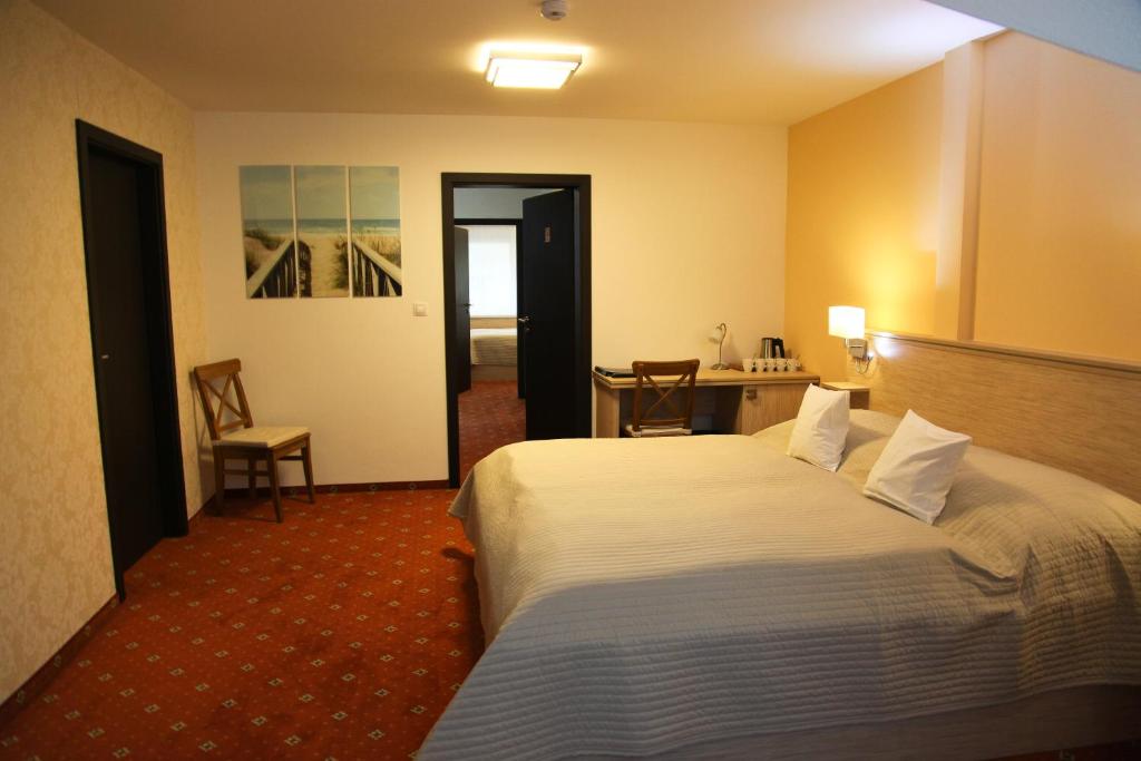 a hotel room with a large bed and a desk at Pension Dvořák in Karlovy Vary