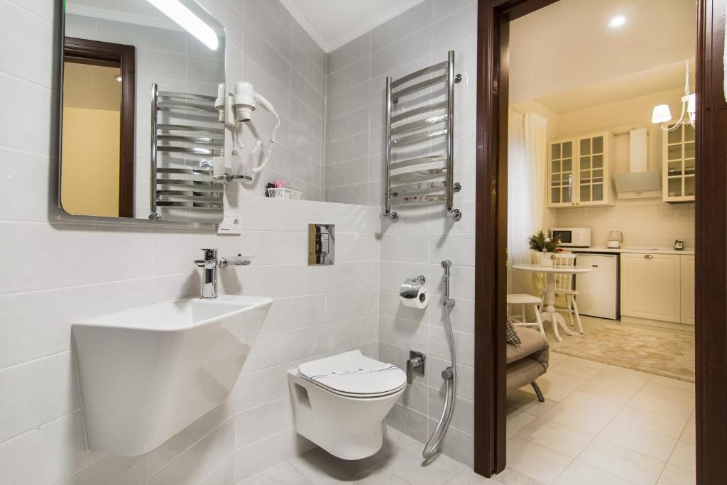 ein weißes Bad mit einem WC und einem Waschbecken in der Unterkunft Apart Hotel Quartet in Odessa
