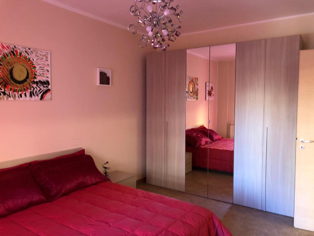 1 dormitorio con cama roja y espejo en A Casa di Siria, en Gela