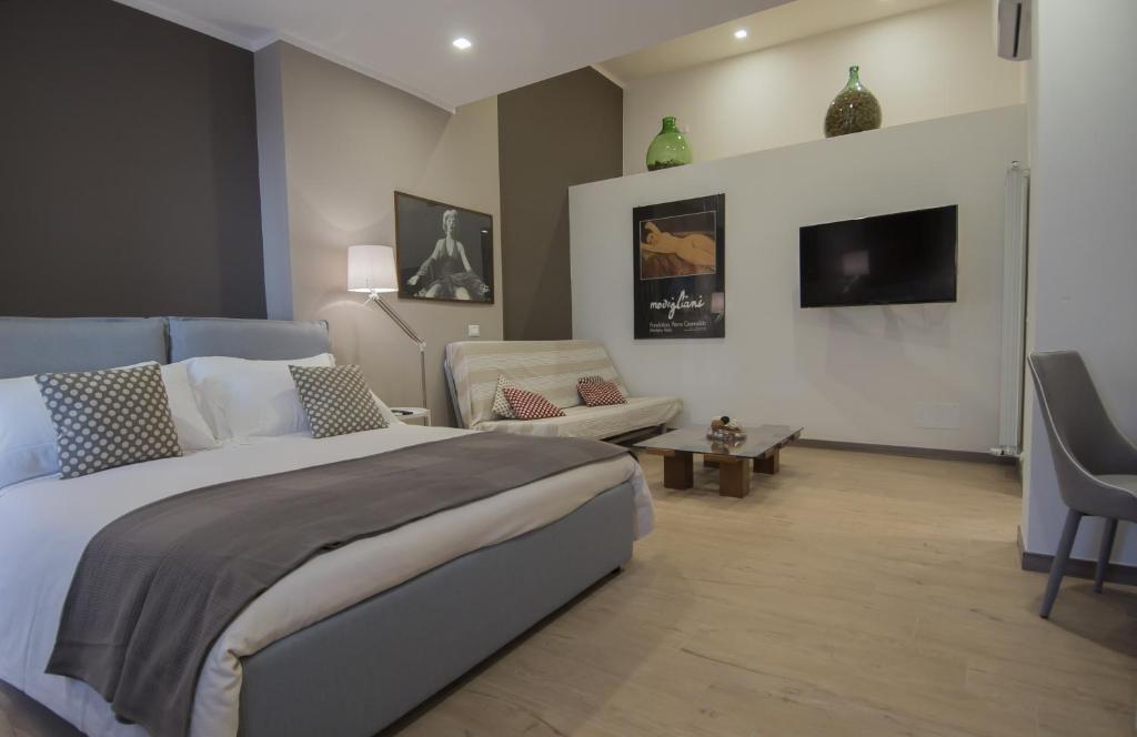 - une chambre avec un lit, un canapé et une télévision dans l'établissement Ca'Vour, à La Spezia