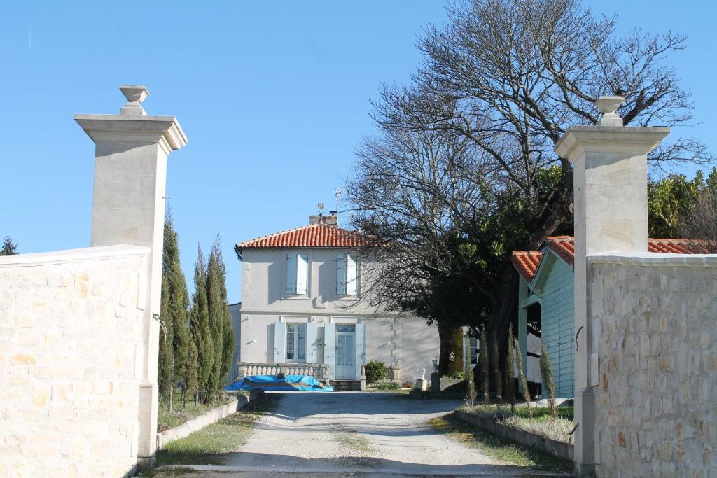 a white house with a gate in front of it at Gîte du Château in Allas-Bocage