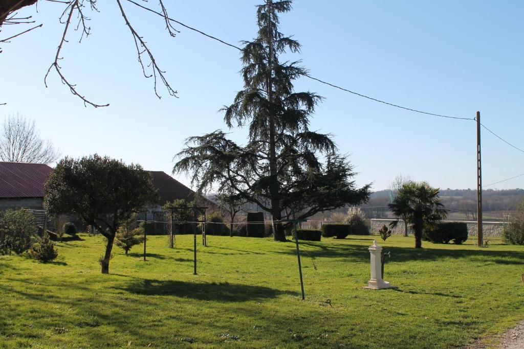 a park with trees and a fire hydrant in the grass at Gîte du Château in Allas-Bocage