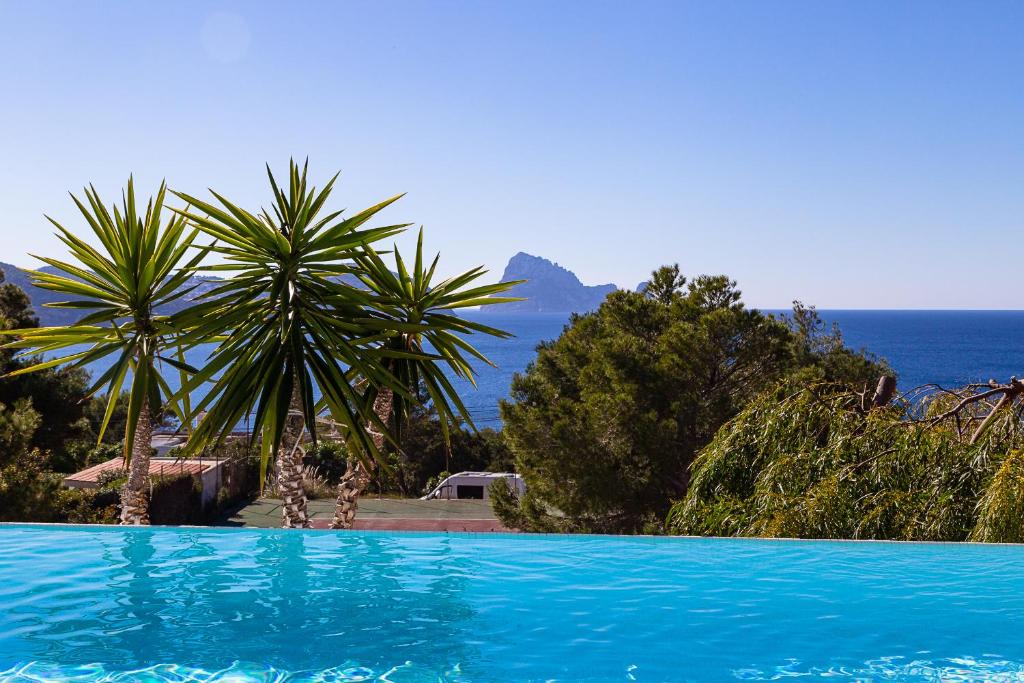 a blue swimming pool with a view of the ocean at Can Bernadet in San Jose