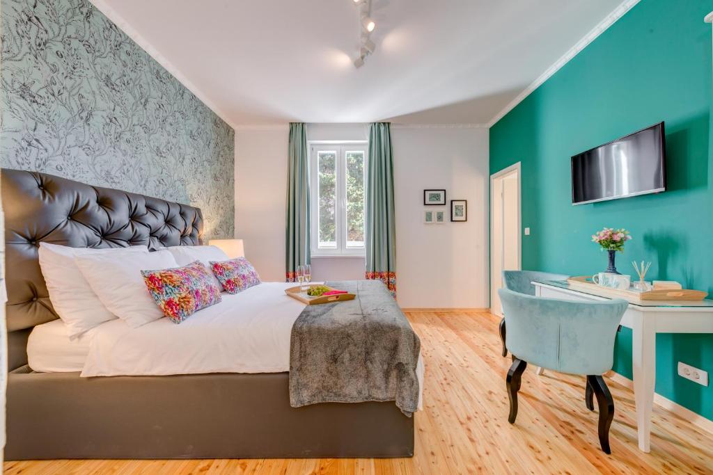- une chambre avec un grand lit et un bureau dans l'établissement Deluxe Rooms Tramonto, à Split