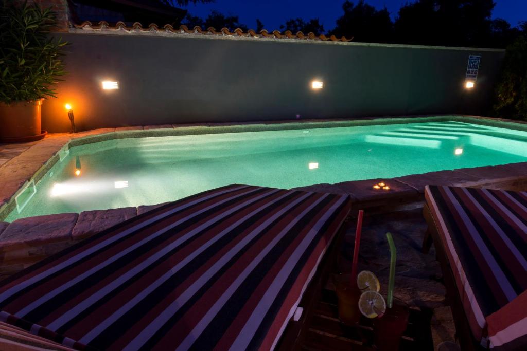 una piscina notturna con due sedie a sdraio davanti di FERIENHAUS GRETA a Vodnjan (Dignano)