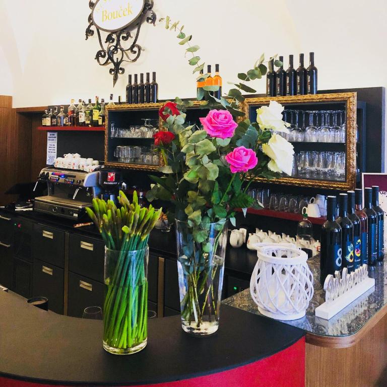 a counter with two vases with flowers on a table at Hotel Bouček in Kroměříž