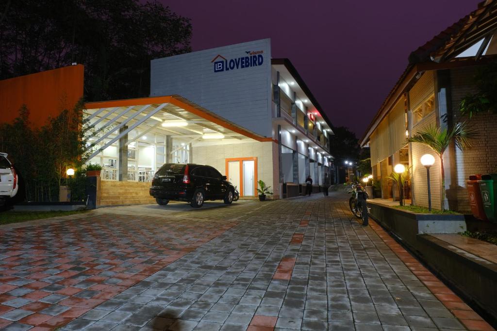 a car parked in front of a building at night at Wisma Lovebird in Kalianget