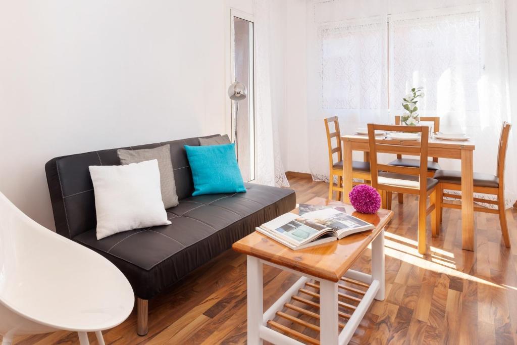 sala de estar con sofá negro y mesa en Click&Flat Fira Gran Via, en Hospitalet de Llobregat