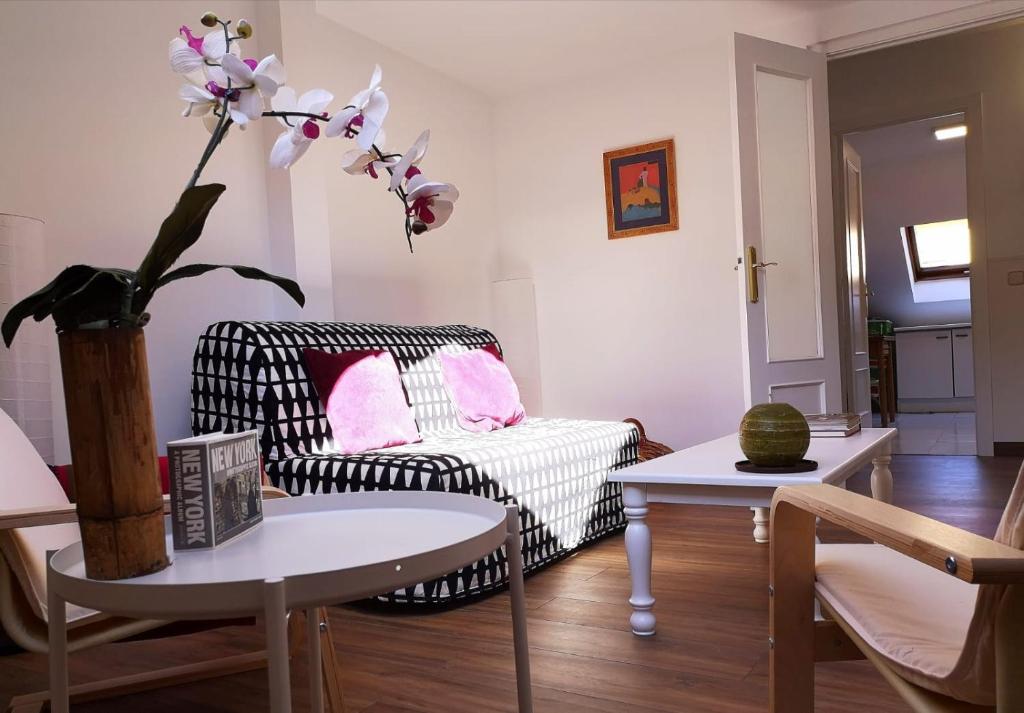 ein Wohnzimmer mit einem schwarzen und weißen Stuhl und einem Tisch in der Unterkunft Apartamento en Centro Historico de San Lorenzo de El Escorial in San Lorenzo de El Escorial