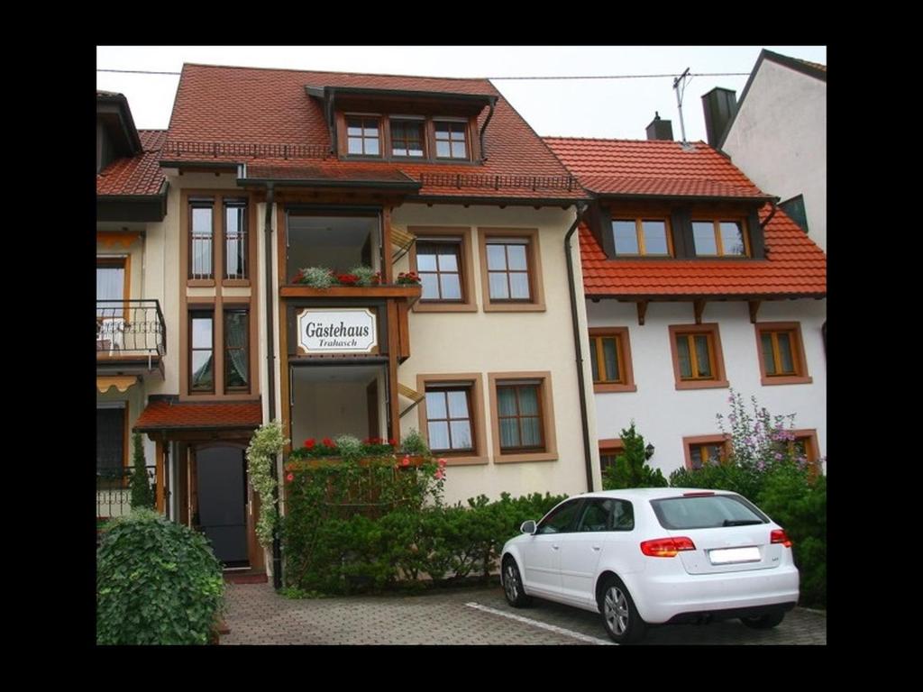 un coche blanco estacionado frente a una casa en Gästehaus Trahasch im Adelshof, en Endingen am Kaiserstuhl