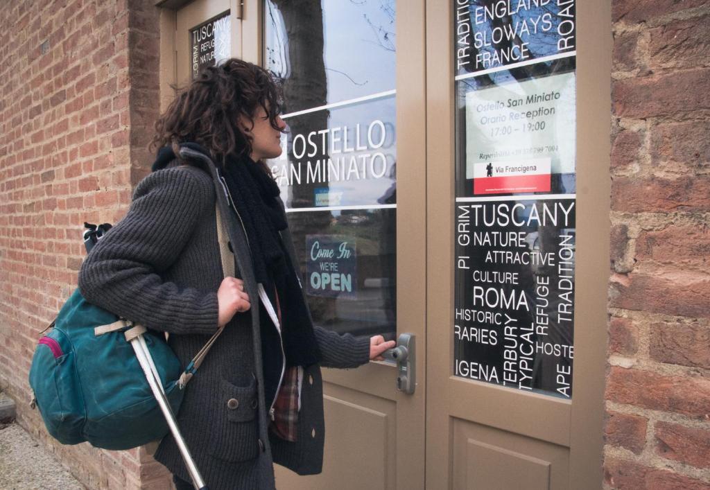 Une femme qui sort d'une porte dans l'établissement Ostello San Miniato, à San Miniato