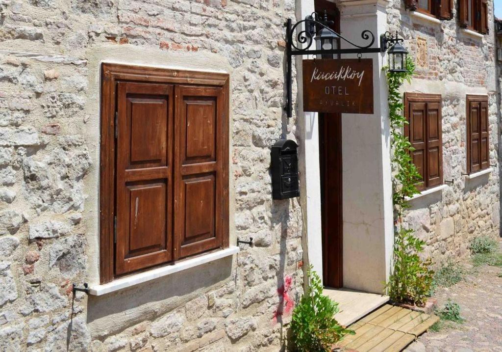 a building with a wooden door and a sign on it at Küçükköy Otel in Ayvalık