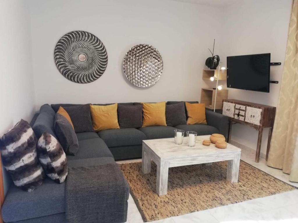 a living room with a blue couch and a table at Villa Cristina in Puerto del Carmen