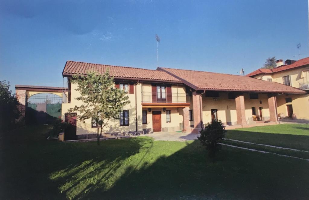 a large house with a green lawn in front of it at Cascina Tetto del Priore in Cuneo