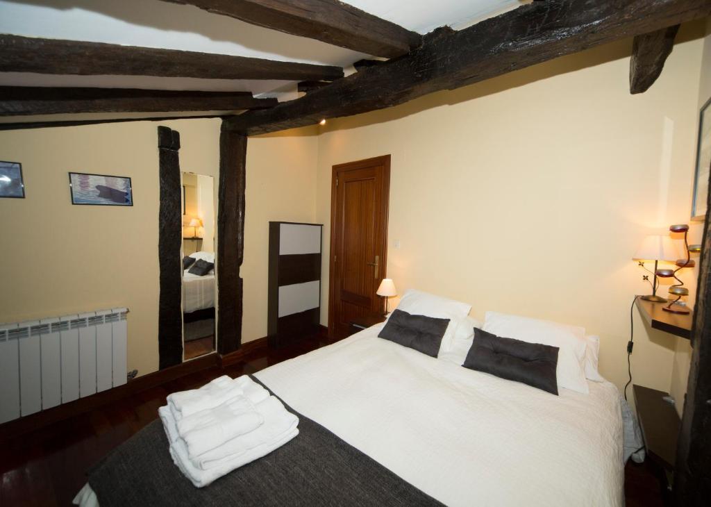 - une chambre avec un lit doté de draps et d'oreillers blancs dans l'établissement La Casa Roja de Saioa, à Lekeitio