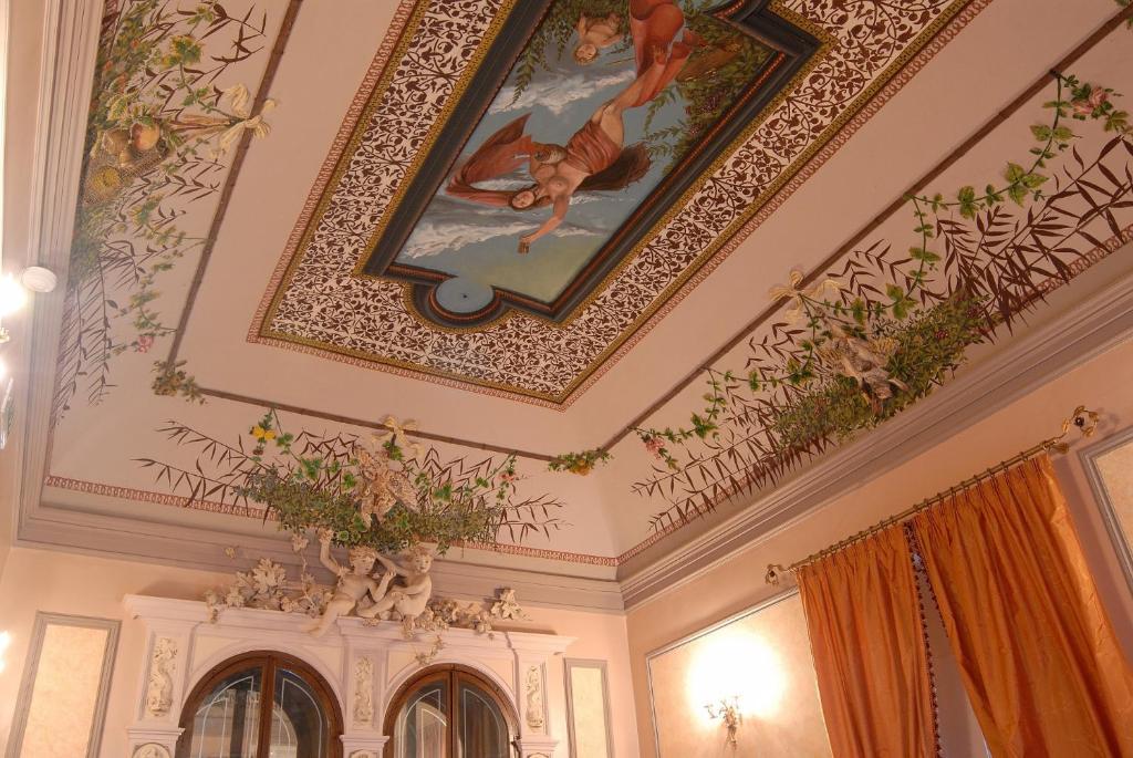 a room with a painting on the wall and a clock on the wall at Hotel Gresi in Catania