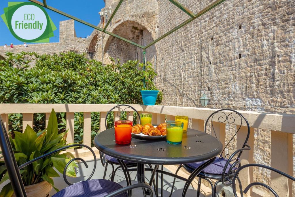 a table with a plate of fruit on a balcony at Dominium Old City Suite in Dubrovnik