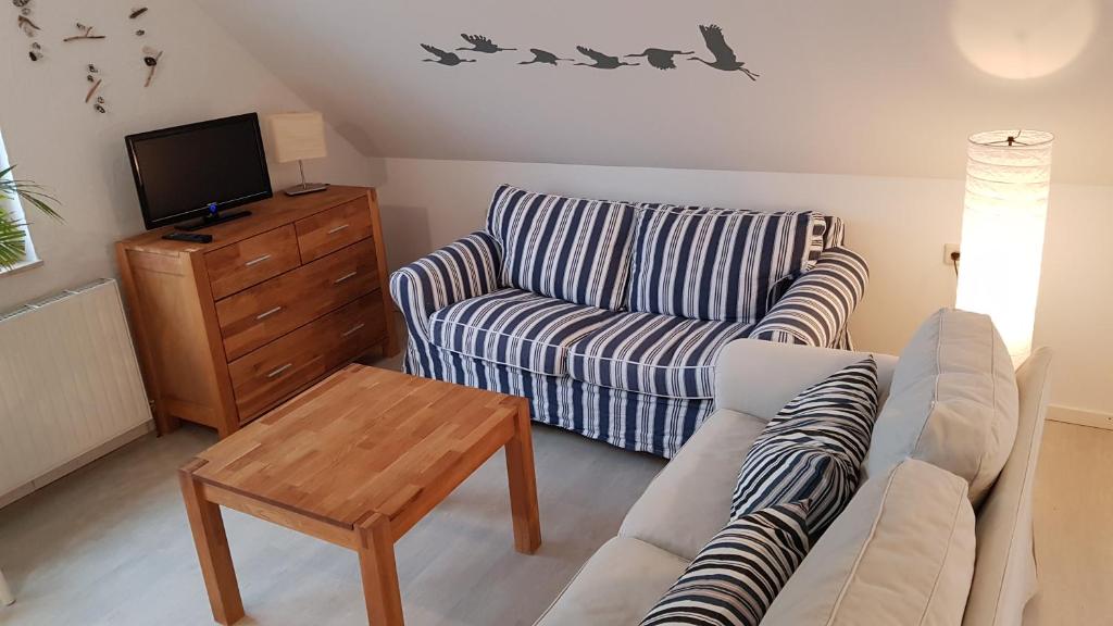 a living room with a couch and a chair at Ferienwohnung Kranichblick in Zingst