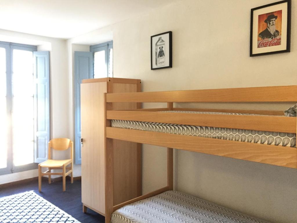 a room with a bunk bed and a chair at Gîte du Chalet Pietri in Olivese