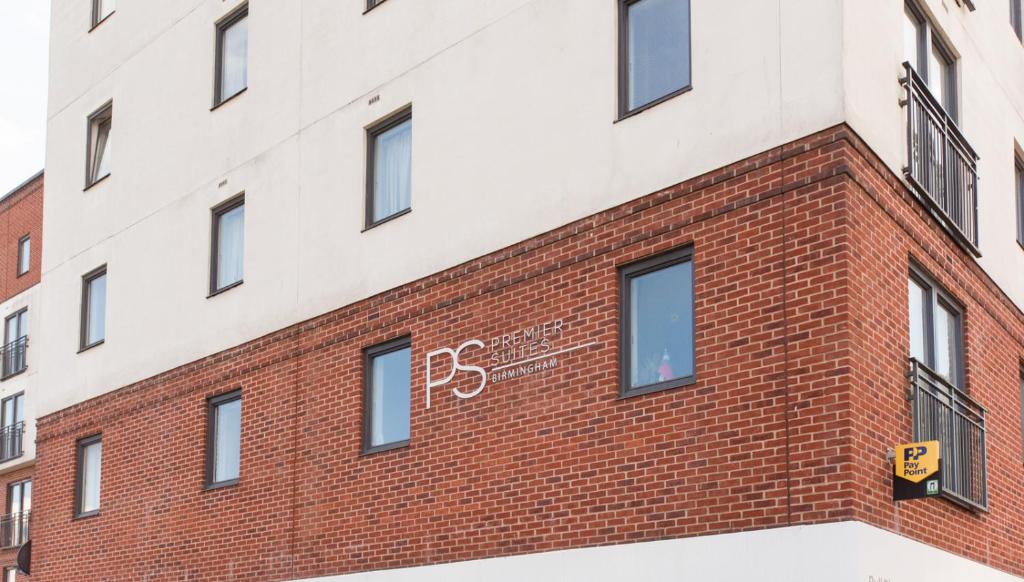 a brick building with a clock on the side of it at PREMIER SUITES Birmingham in Birmingham