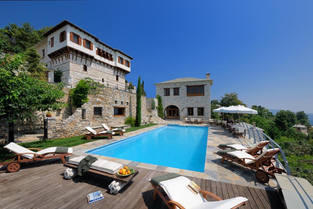 a villa with a swimming pool in front of a building at Sakali Mansion in Pinakátai