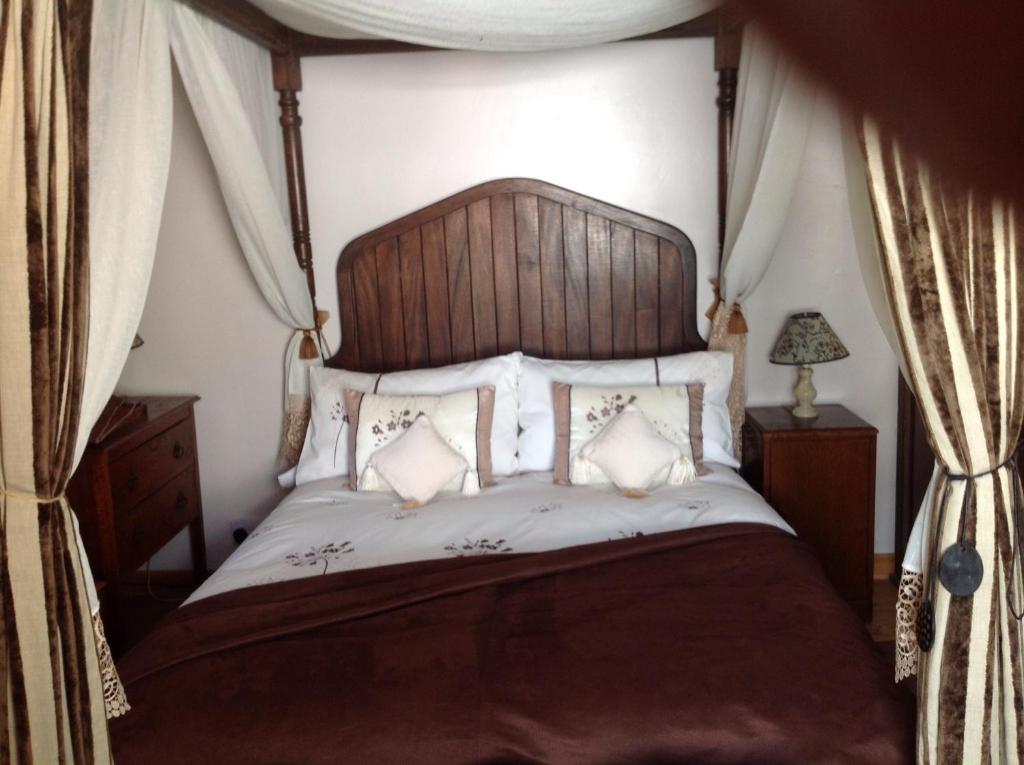 a bedroom with a large bed with a wooden headboard at Alice Guest house in Cheltenham