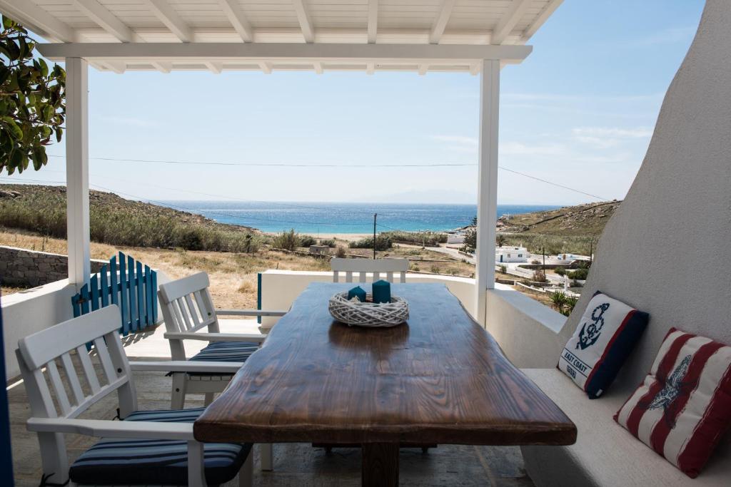 un tavolo e sedie su una veranda con vista sull'oceano di Venus Myconian Residences a Kalafatis