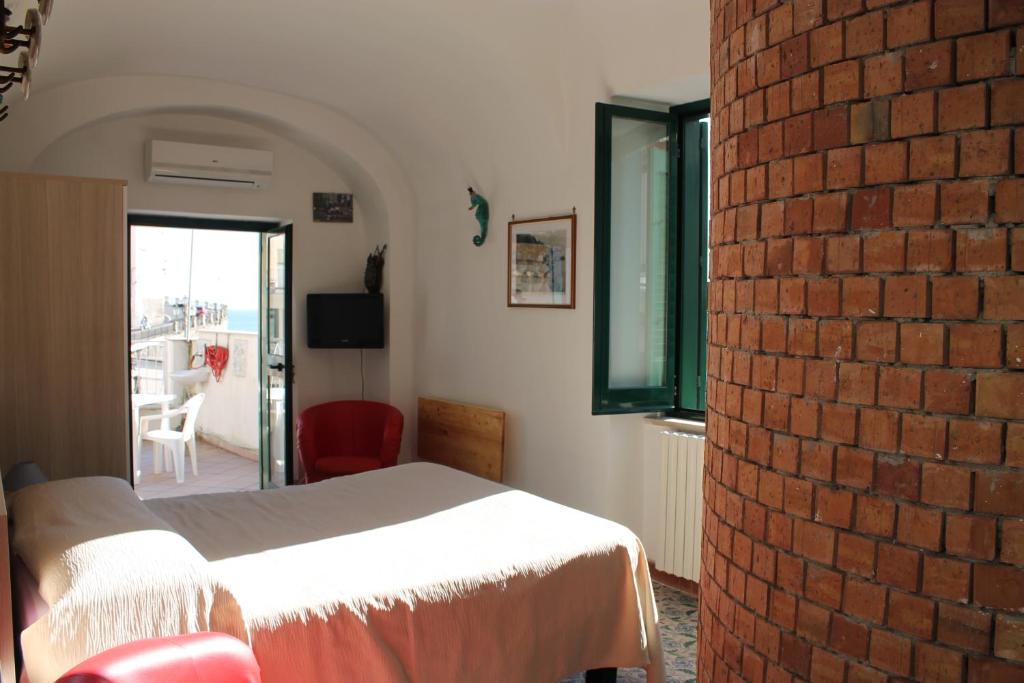 1 dormitorio con cama y pared de ladrillo en Attico del Cavaliere, en Atrani