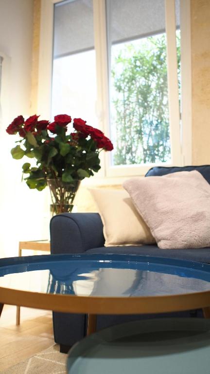 a living room with a blue couch and a glass table at Esprit Bordelais in Bordeaux